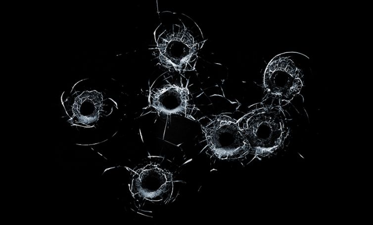 Broken Glass Multiple Bullet Holes In Glass Isolated On Black