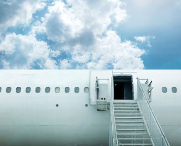 open door and stairstep from airplane with blue sky for luxury travel