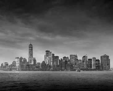 Dramatic panoramic view of storm over Lower Manhattan from Ellis Island at dusk, New York City. Black and white image.