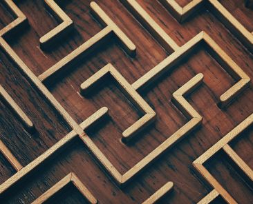 Close up of dark brown wooden labyrinth maze, toy puzzle game, elevated high angle view