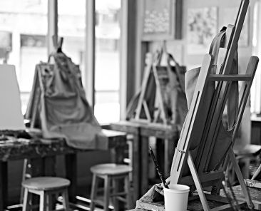 Interior of the creative art workshop with wooden easels and painting equipment