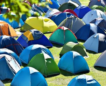 Lots of colorful tents on a meadow in a summer day during music festival