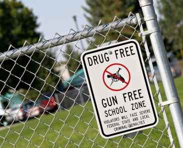 drug and gun free school zone sign at a school yard. sign of the times.