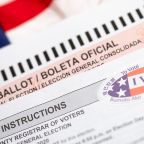 Official Ballot and Voting Instructions with I Voted Sticker Laying on American Flag.