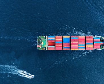 Aerial view of Manufacturing logistics cargo container ship at ship port export import business logistic international custom Checking Shipping cargo to harbor by Big crane on fluffy clouds blue sky